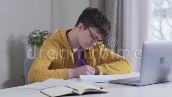 戴眼镜的聪明白种人男孩的肖像看着母亲带来的一叠书唱歌累了的学生视频的预览图