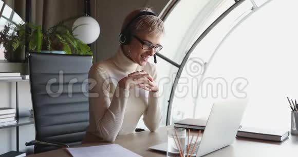 商务女性戴着耳机会议在办公室打电话给笔记本电脑视频的预览图