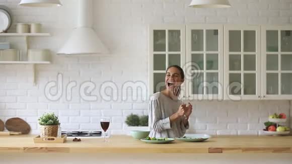 兴奋的千禧混血女人在厨房唱最喜欢的歌视频的预览图