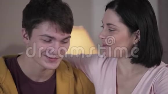 年轻的白种人的母亲和十几岁的儿子近距离的交谈看着镜头微笑幸福女人的画像视频的预览图