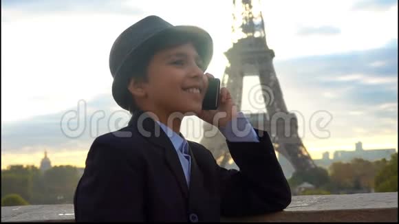 男孩在埃菲尔铁塔的背景下通过电话交谈视频的预览图