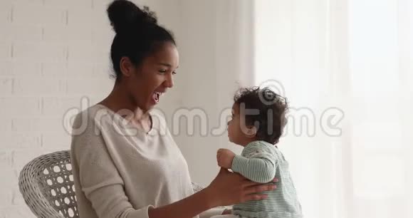 可爱的快乐混血妈妈在玩抱可爱的小女儿视频的预览图