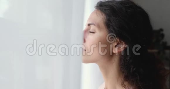 冷静的女士在窗口深呼吸新鲜空气视频的预览图