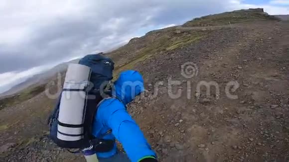 微笑青年男子徒步穿越崎岖的冰岛地形在Fimvorduhals的大风中每秒可达30名拳击手视频的预览图