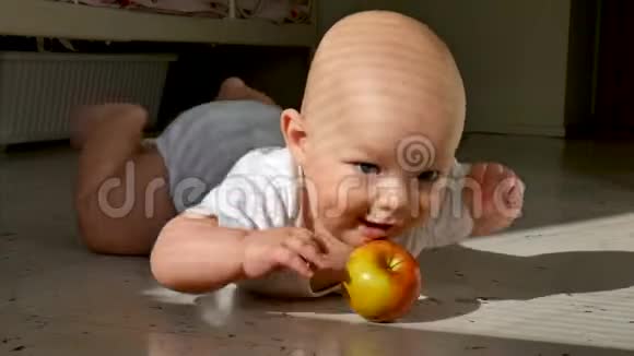 宝贝躺在地板上拿着一个红苹果4这个孩子活泼开朗积极主动视频的预览图