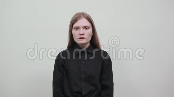 不高兴的白种人年轻女子穿着黑色衬衫张开手尖叫视频的预览图