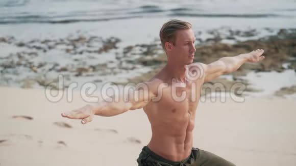 肌肉发达的人在日落时在海滩上做瑜伽练习动作缓慢视频的预览图