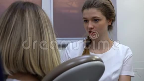 牙医和坐在椅子上舒服的女病人交谈视频的预览图