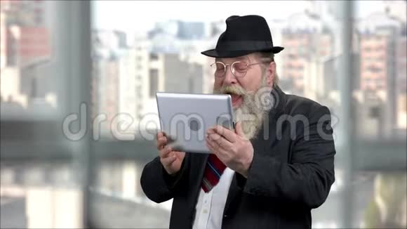 一位穿着平板电脑西装的老人的画像大声笑了出来视频的预览图