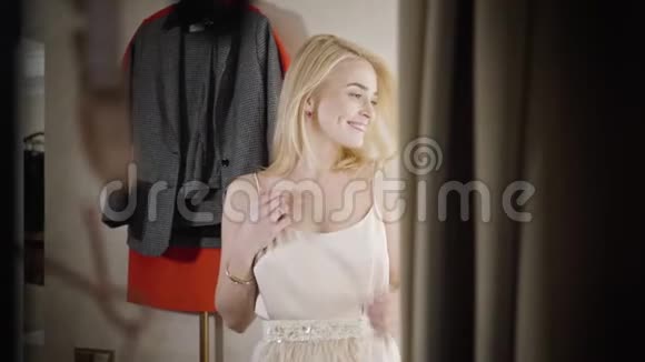 在时尚精品店更衣室快乐美丽的女购物狂纺纱年轻的白人金发女人视频的预览图