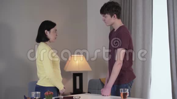 成年白种人妇女和十几岁男孩在室内争吵和做手势的侧视儿子和妈妈吵架视频的预览图