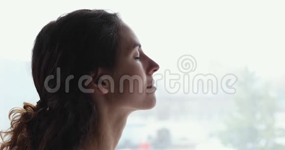 一位年轻的女士闭上眼睛呼吸新鲜空气视频的预览图