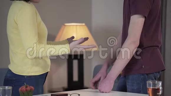 两个面目全非的高加索人在室内争吵母亲和儿子在感情上做手势女人推着十几岁的儿子视频的预览图