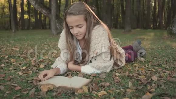 少女躺在林边草地上看书视频的预览图