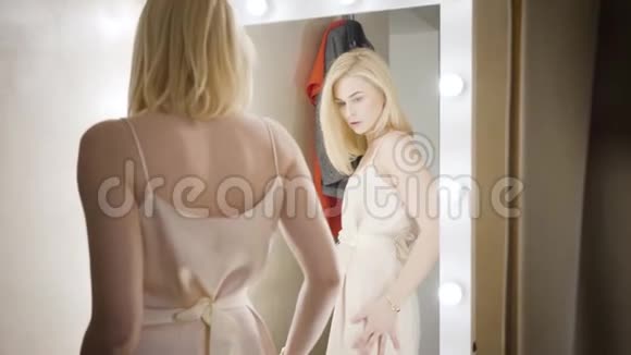 年轻的高加索女人在更衣室里穿着优雅的衣服镜头移下穿着米色衣服的富有女士视频的预览图
