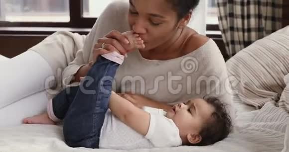非洲妈妈在床上和可爱的小宝宝接吻视频的预览图