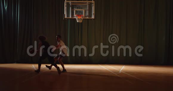 两名篮球青年队员打篮球比赛防守进攻夜间比赛黑暗视频的预览图