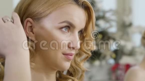 一位年轻的红发白种人女士的特写脸她微笑着在美容院梳一头面目全非的发型师视频的预览图