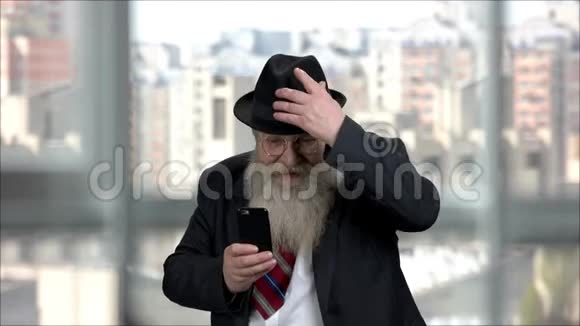 表情开朗的长胡子老人用手机拍照视频的预览图