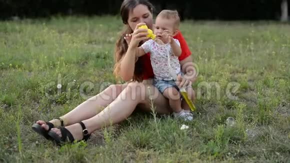 快乐的母女在公园里吹泡泡视频的预览图