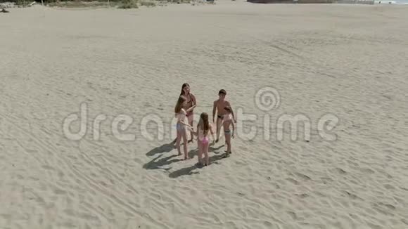 五个穿着泳衣的孩子在沙滩上奔跑视频的预览图
