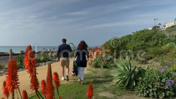 快乐的一对夫妇在海滩上牵手散步享受美好的一天旅游度假退休生活方式概念视频的预览图