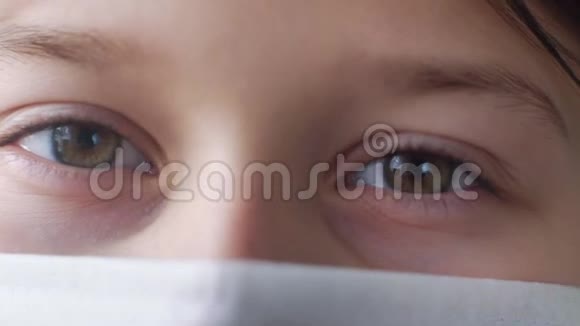 戴医疗面具的小女孩眼睛的宏观镜头视频的预览图