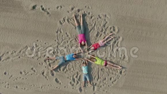 孩子们躺在沙子上像星星一样挥动双手视频的预览图