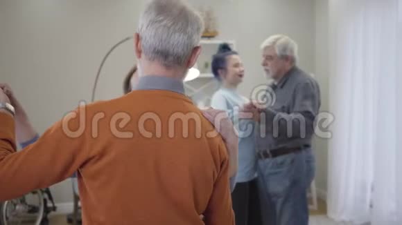 快乐的高加索老人在养老院跳舞孤独老人退休后与志愿者在视频的预览图
