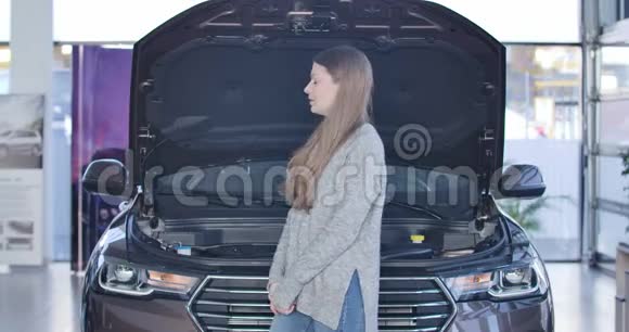 年轻有压力的女人站在破车旁边打开引擎盖用手抱着头白种人黑种人视频的预览图
