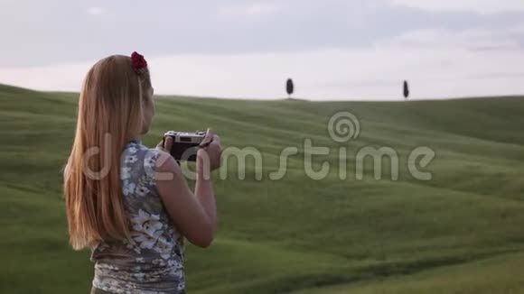 年轻的女性旅行者在夕阳下拍摄美丽的托斯卡纳风景视频的预览图