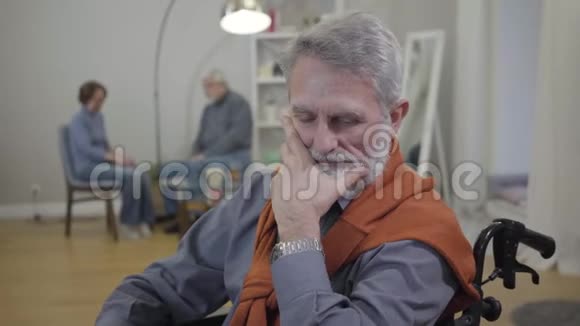 年长优雅的白种人手握下巴思考坐在轮椅上的退休老人画像视频的预览图