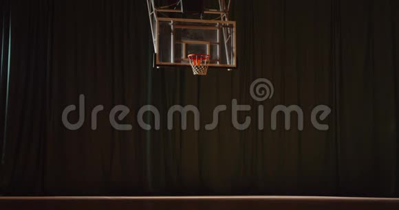 年轻的白种人卷曲篮球运动员把球扔进篮筐进行夜间训练视频的预览图