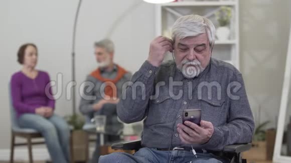 白种人在养老院听音乐的成熟的微笑肖像老年男性退休人士戴耳机及视频的预览图