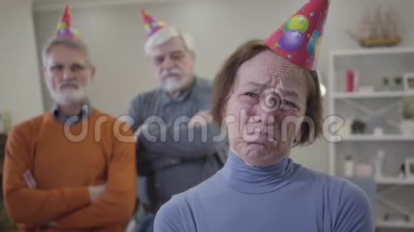 戴着派对帽的老白种人女人的特写脸愤怒的退休老人在养老院庆祝生日视频的预览图