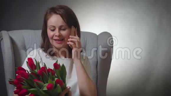 带着郁金香花束的女人打电话视频的预览图