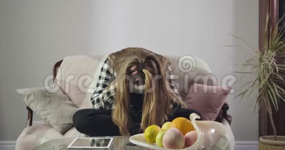 恶心的白人女孩坐在沙发上双手抱着头有问题的压力青少年画像视频的预览图