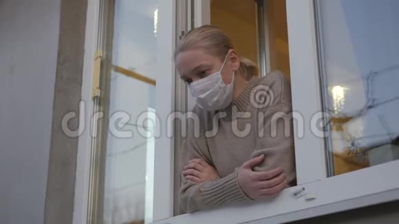 一个戴着医用面具的女人望着窗外视频的预览图