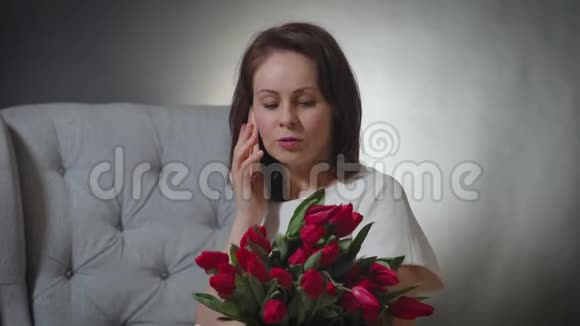 带着郁金香花束的女人打电话视频的预览图