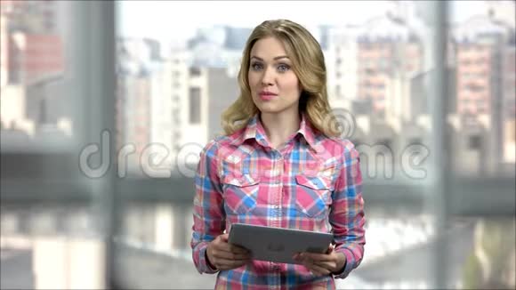 年轻的女士带着平板电脑在办公室做演示视频的预览图