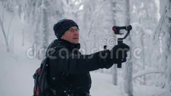 男子旅行者博客记录视频电影行动摄像头冬季森林视频的预览图