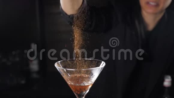 酒保点燃鸡尾酒在黑色背景的酒精饮料中燃烧肉桂慢条斯理的鸡尾酒杯里的火焰视频的预览图