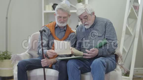 高加索人给养老院的朋友看黑白照片两名正成熟退休人员视频的预览图