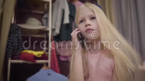 一个时尚的金发白种人女孩的特写在电话里说话在指甲上吹气自信的年轻时尚小姐视频的预览图