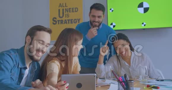 阳光办公室的年轻同事使用平板电脑在线电话会议变色的笑声视频的预览图