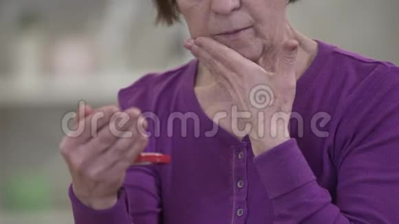 无法辨认的白人老女人用手摸着脸看着镜子失去工作的沮丧的退休老人视频的预览图
