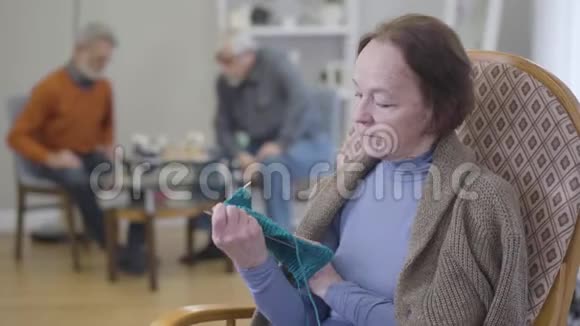 成熟的白种人女人正在检查编织的特写肖像老年女性退休人员在养老院执业爱好视频的预览图