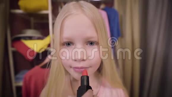 可爱的白人女孩涂口红的特写脸迷人的金发孩子化妆时尚风格美视频的预览图