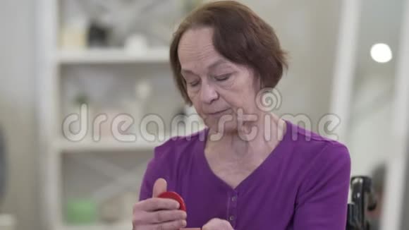 忧郁的老白种人女人用阴沉的表情看着手镜的肖像老年女性视频的预览图