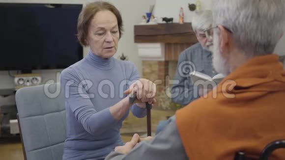 白发苍苍的白种人成熟男人用手杖安抚老妇人退休长者互相支援视频的预览图